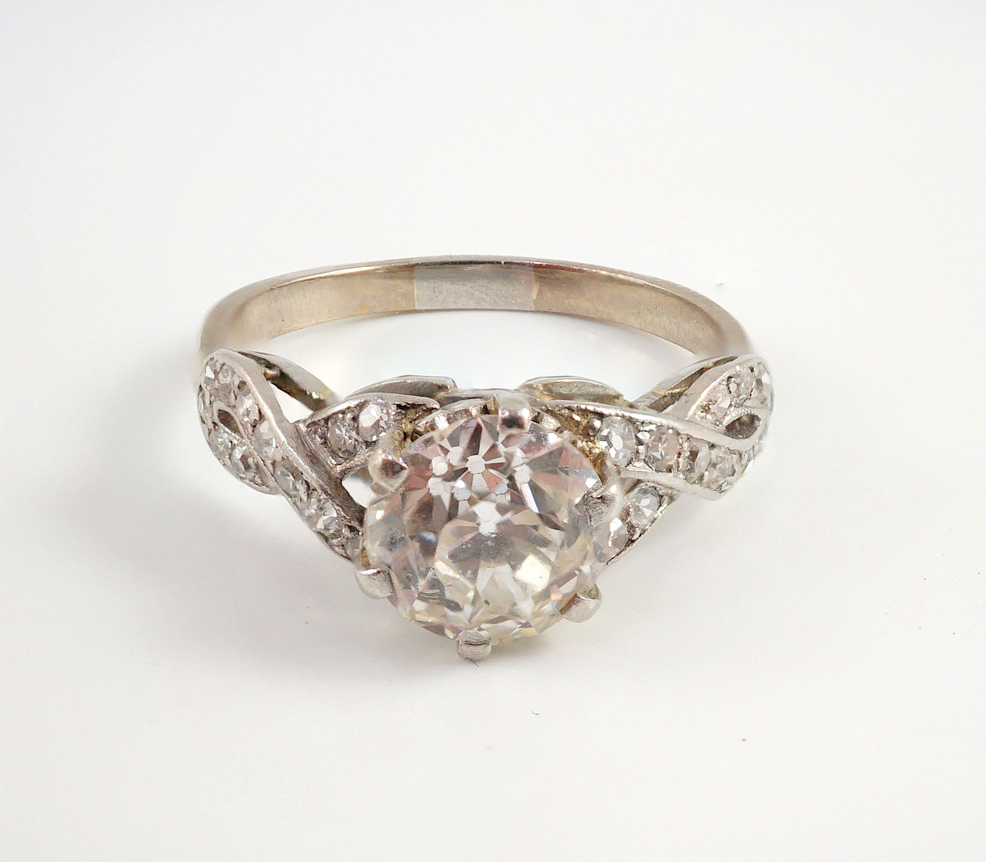 A mid 20th century white gold and single stone diamond ring, with diamond set crossover shoulders